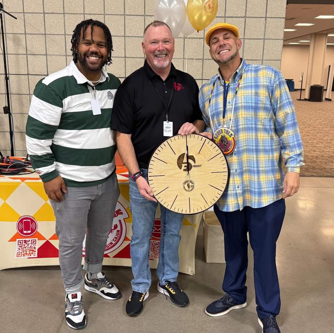 Brandon with two men at a recovery event, one holding a SoberTalk clock