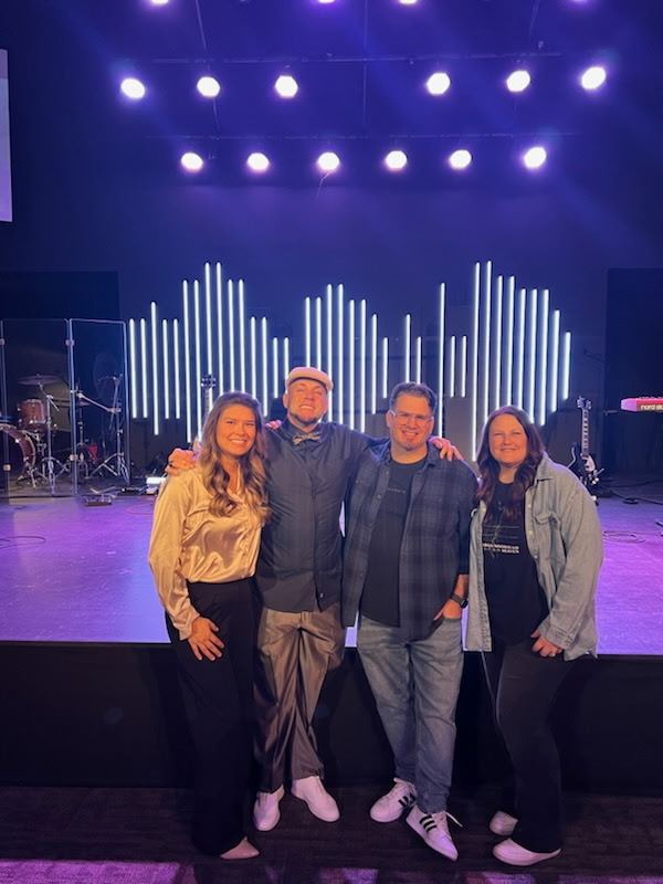 Brandon with friends on a church stage