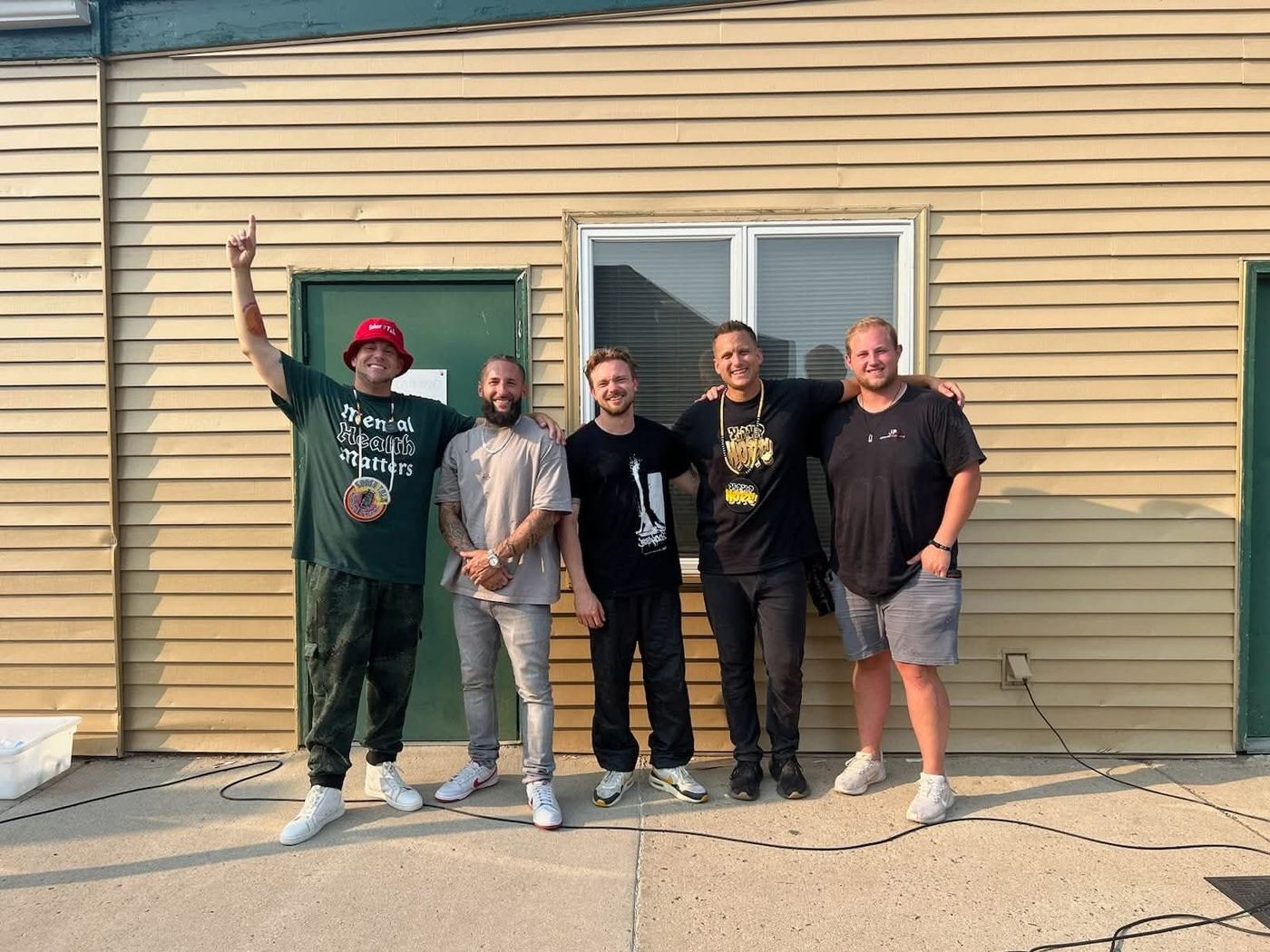 Brandon and friends outside a recovery event, Brandon pointing to the sky