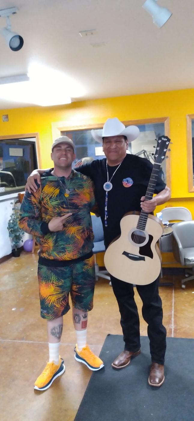 Brandon arm-in-arm with a guitarist in a cowboy hat