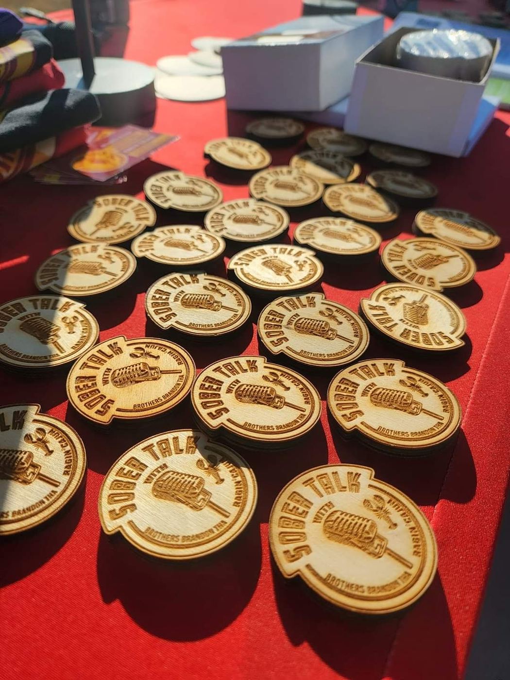 Wooden SoberTalk medallions laid out on a red table