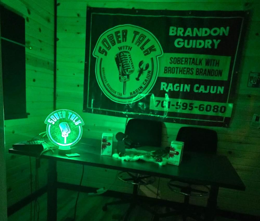 The SoberTalk studio in Bismarck: the show banner, mic sign and two seats at the desk
